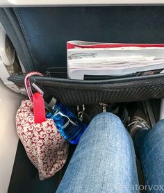 someone is sitting in an airplane with their feet on the seat belt and there are many items inside