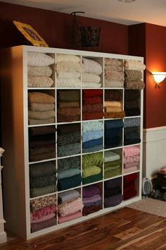 a closet filled with lots of folded towels and blankets on top of shelving units