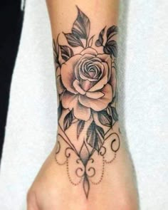 a woman's hand with a rose tattoo on it