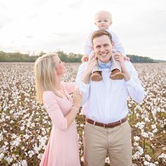 a man holding a baby in his arms while standing next to a woman