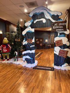 the entrance to an office decorated for christmas with decorations and trees in the hallway behind it