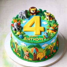 the birthday cake is decorated with animals and trees