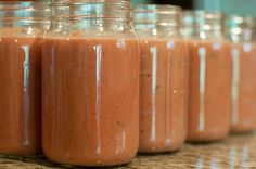 several jars filled with smoothie sitting on top of a counter