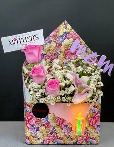 pink roses and white flowers in a house shaped box with a birthday card on top