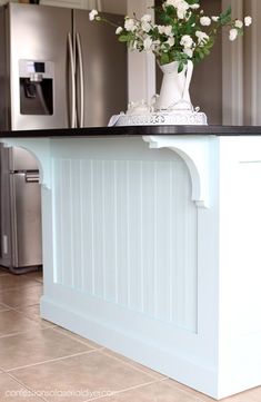 a vase with flowers on top of a kitchen island