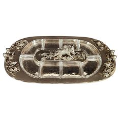 a silver tray with a horse and flowers on the bottom, sitting in front of a white background