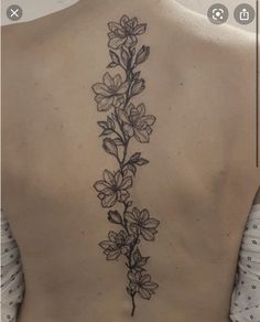 the back of a woman's neck with flowers on it