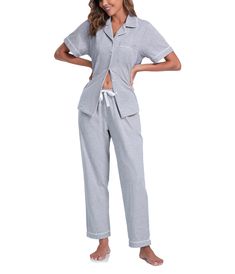 a woman in grey pajamas and white shoes posing for the camera with her hands on her hips