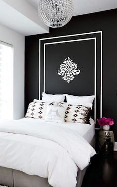 a bedroom with black walls and white bedding