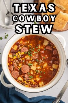 a white bowl filled with chili and corn next to bread on a blue towel, along with the words texas's cowboy stew