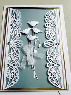 a card with white paper cut flowers on it