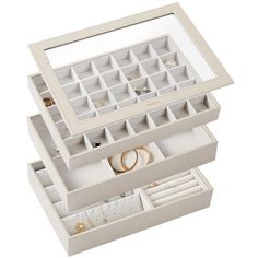 two white jewelry boxes filled with rings and bracelets