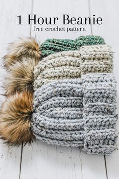 the crochet beanie with two pom - poms is shown on a wooden