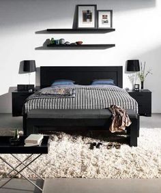 a bedroom with white carpet and black furniture