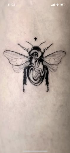 a black and white bee tattoo on the stomach