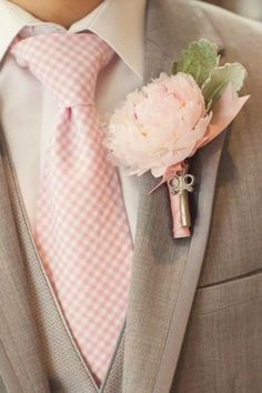 a man wearing a suit and tie with a pink flower on it's lapel