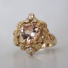 a fancy ring with a heart shaped stone in the center