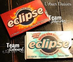 two boxes of eclipse gum sitting on top of a wooden table next to each other