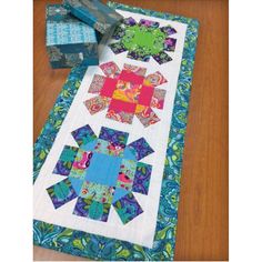 a table runner made out of scrap paper and fabric with an appliqued design on it