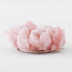 a spoon filled with pink sugar on top of a white table