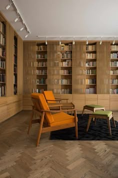 two chairs and a table in a room with bookshelves