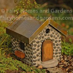 a small house made out of rocks and stones with a door in the center is shown