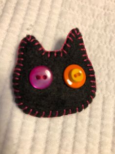 a close up of a cat brooch with buttons on it's back side