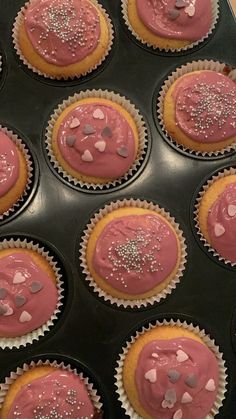 cupcakes with pink frosting and silver sprinkles in a muffin tin