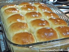 a baking dish filled with bread rolls on top of a stove