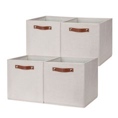 three canvas storage bins with leather handles, one in white and the other in brown