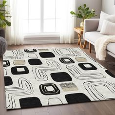 a white rug with black and beige shapes on it in front of a window next to a couch