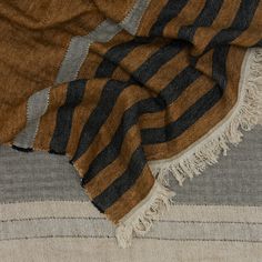 a brown and black striped blanket laying on top of a bed