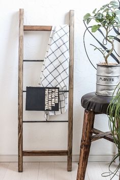 a wooden ladder sitting next to a potted plant