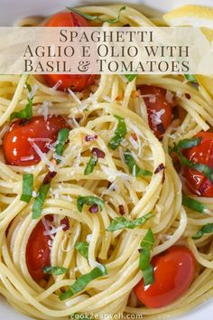 spaghetti with basil and tomatoes in a white bowl