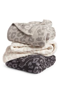 three towels stacked on top of each other in different colors and patterns, with one folded up