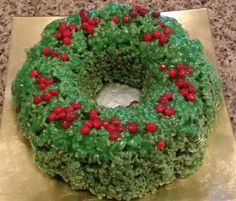 a green cake with red berries on it