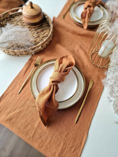 the table is set with gold and white plates, napkins, and utensils