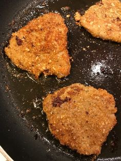 three pieces of chicken cooking in a frying pan