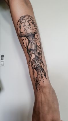 a person's arm with a jellyfish tattoo on it