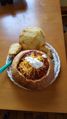 a plate with bread and chili on it