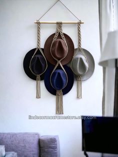 three hats are hanging on the wall with ropes and tassels attached to them