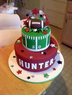 a three tiered cake decorated with footballs and stars