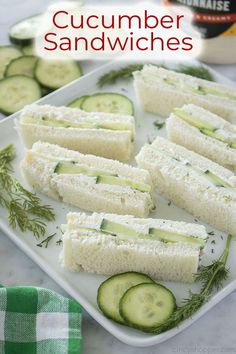 cucumber sandwiches on a plate with pickles and seasoning in the background