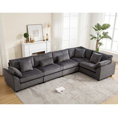 a grey sectional sofa sitting on top of a rug