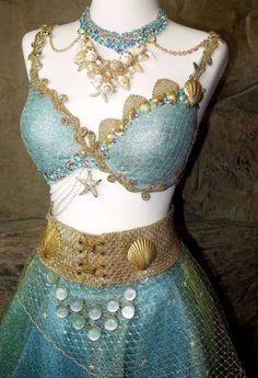 a mannequin wearing a blue and gold costume with shells on it's chest