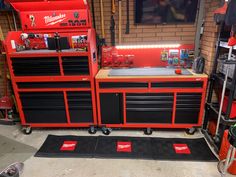 a garage with tools on the floor and red workbenches in front of it