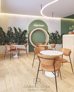 the interior of a restaurant with wooden chairs and round tables in front of a green wall