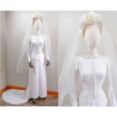 a white wedding dress and veil on display next to a mannequin's head