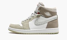 The Women’s Air Jordan 1 High Zoom CMFT “Olive Aura” is a women’s-exclusive colorway of the alternate, modernized version of the retro basketball shoe that includes even more padding than the standard edition. The Zoom Comfort version of the Air Jordan 1 displays a deconstructed look similar to the Off-White x Air Jordan 1 from “The 10” collection from 2017. The upper is constructed with a white leather base with grey hairy suede panels on the toe cap, forefoot, and eyelets. Olive nubuck is foun Air Jordan 1 Mid Linen, Jordan 1 Mid Linen, Logo Wings, Doudoune The North Face, Original Air Jordans, Nike X Travis Scott, Retro Basketball Shoes, Converse Run, Retro Basketball