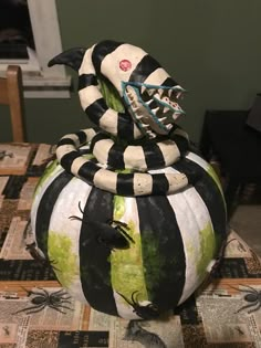 a black and white striped pumpkin sitting on top of a table